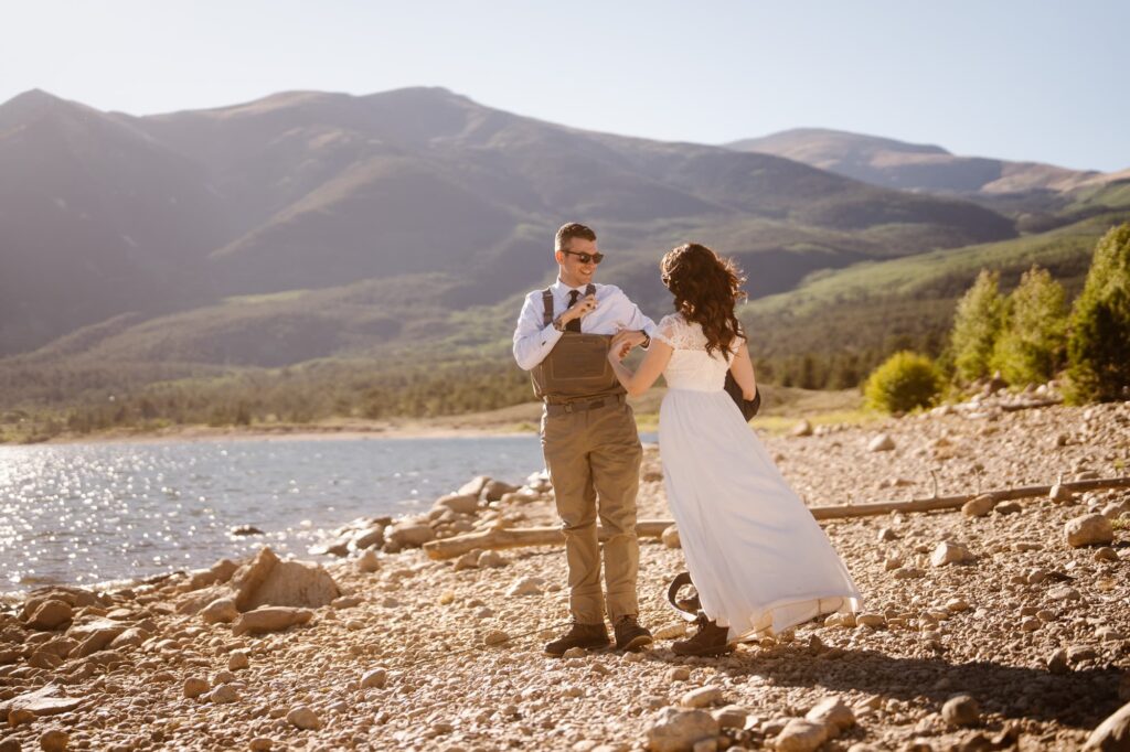 Groom putting waders on for fly fishing on his wedding day