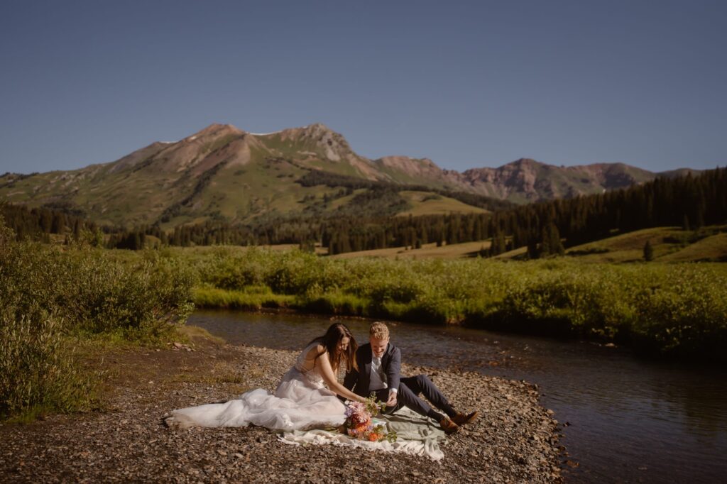 Couple sharing a riverside picnic on a blanket
