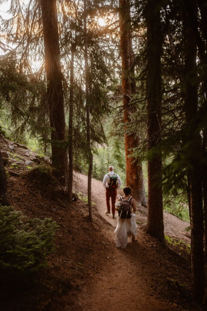 Bride and groom hiking out of the forest on their elopement day