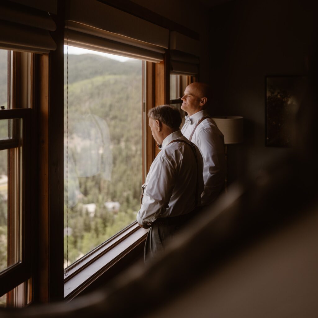 Groom and father of the bride looking out the window over Breckenridge