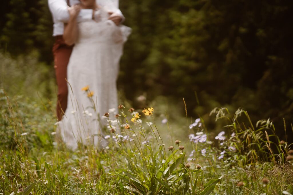 Bride and groom standing amongst wildflowers