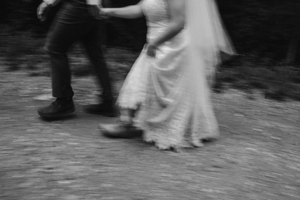 Movement photo of couple walking down the dirt road on their elopement day
