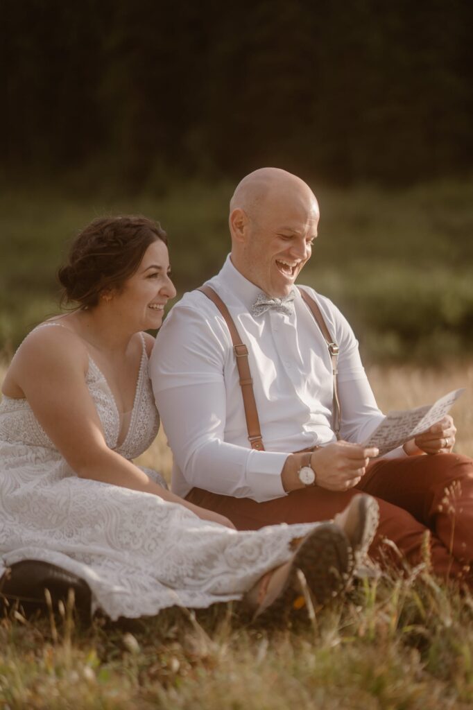 Couple laughing at letters from family and friends on their elopement day