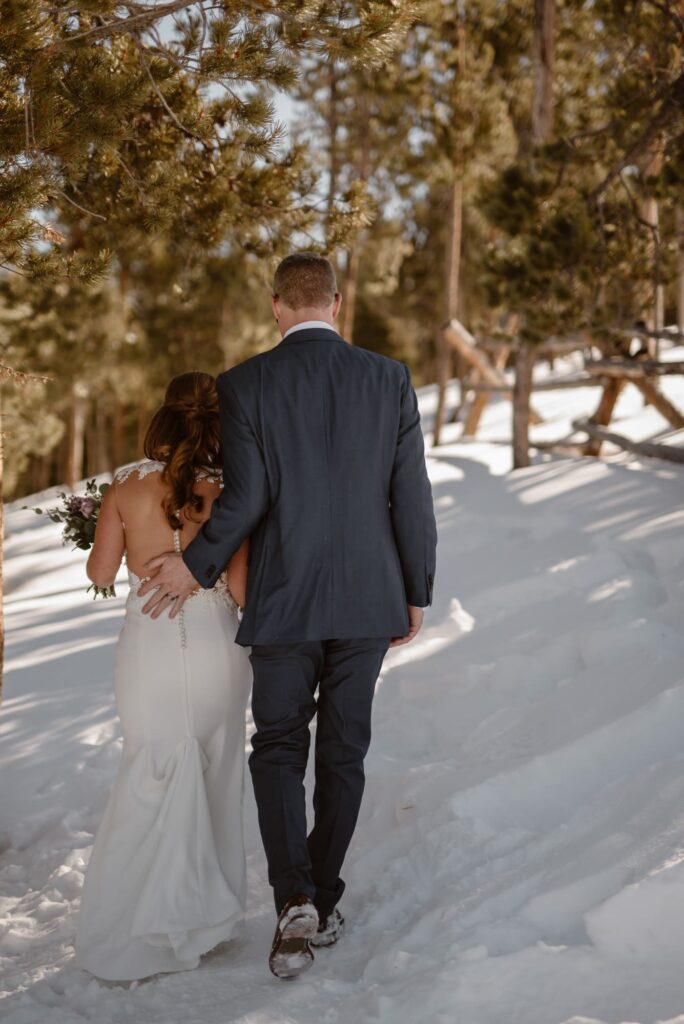 Couple walking through the snow at their elopement