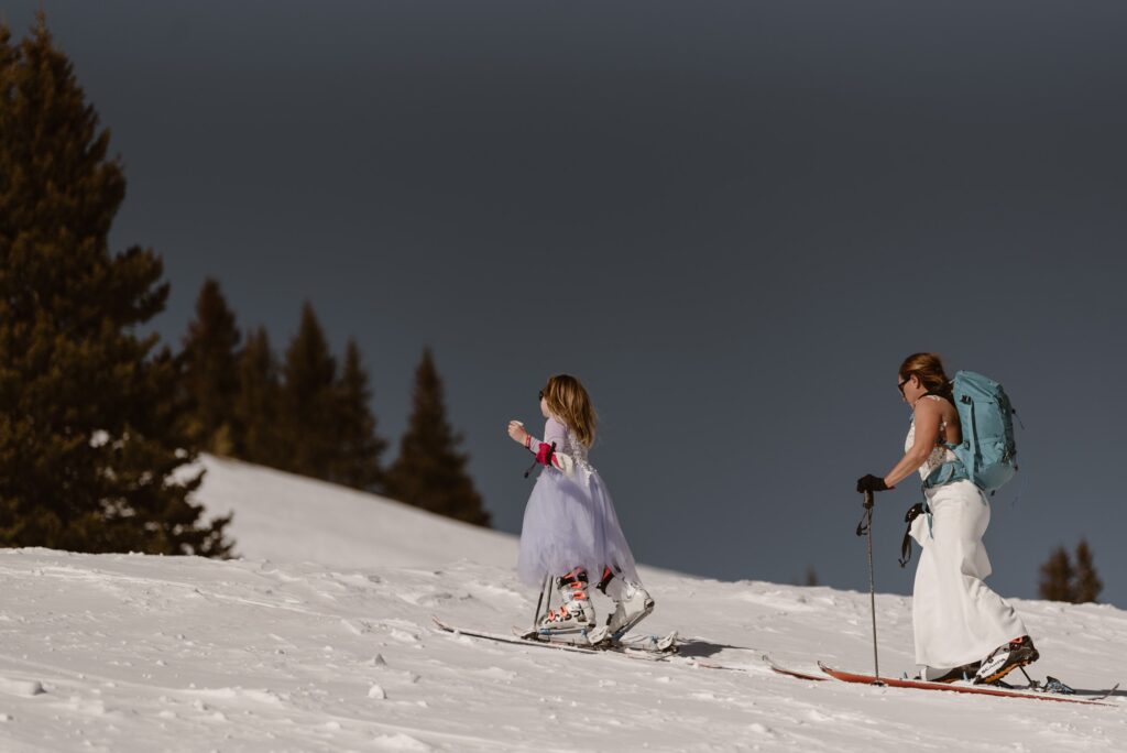 Bride and daughter backcountry skiing on their wedding day