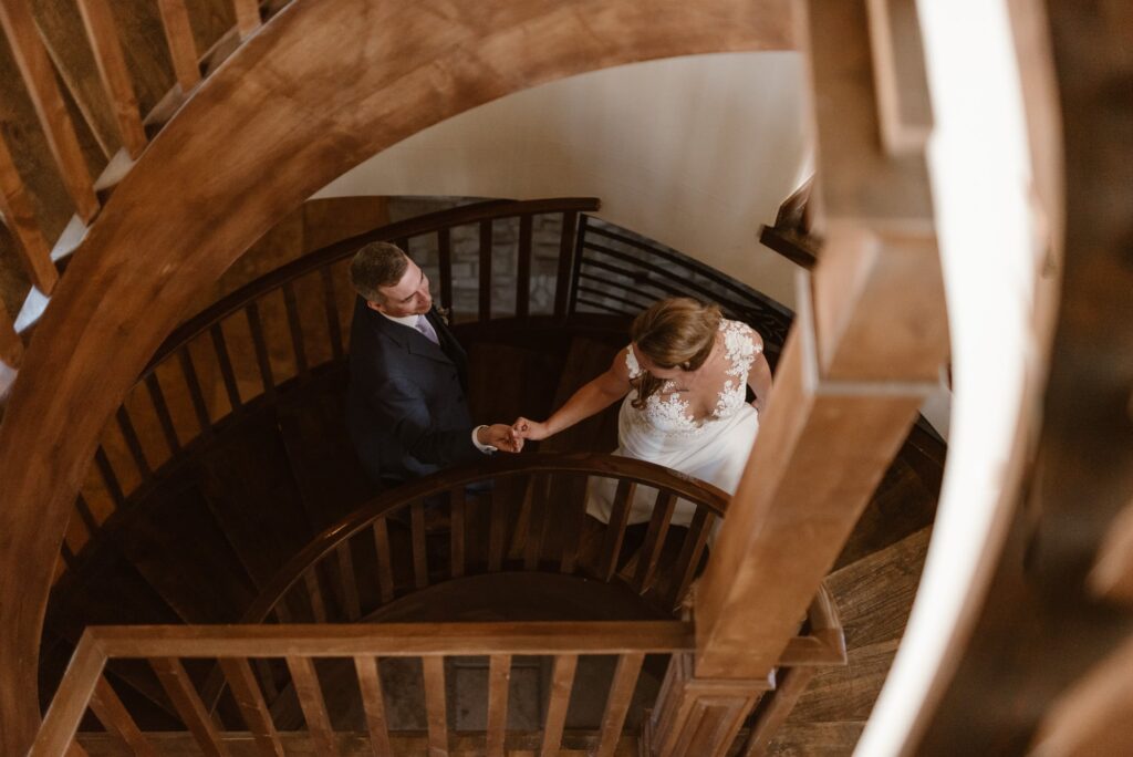 Couple walking down spiral staircase at the Airbnb on their elopement day 