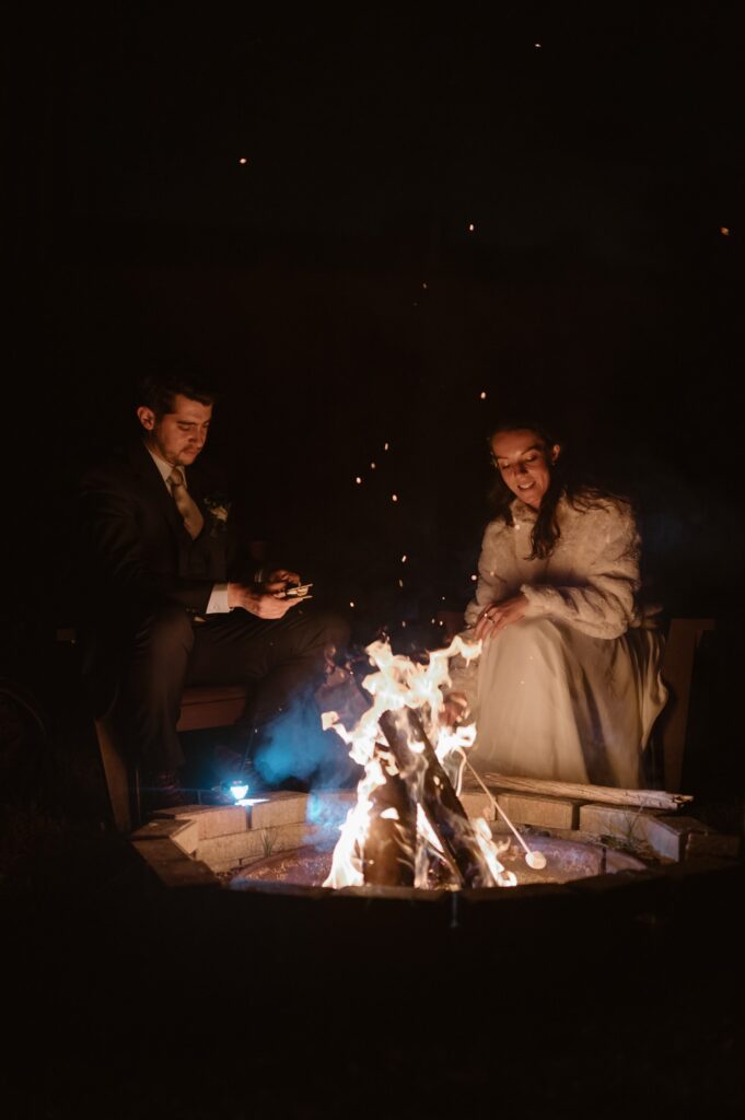 Bride and groom enjoying s'mores and a campfire
