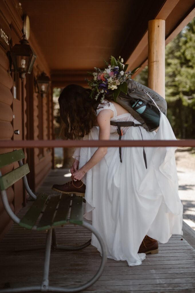 Bride tying her hiking boot on the front porch of the cabin