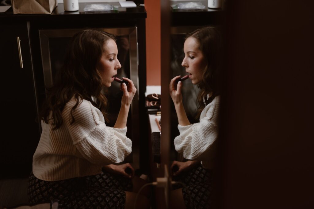 Bride putting lipstick on and getting ready for her National Park wedding