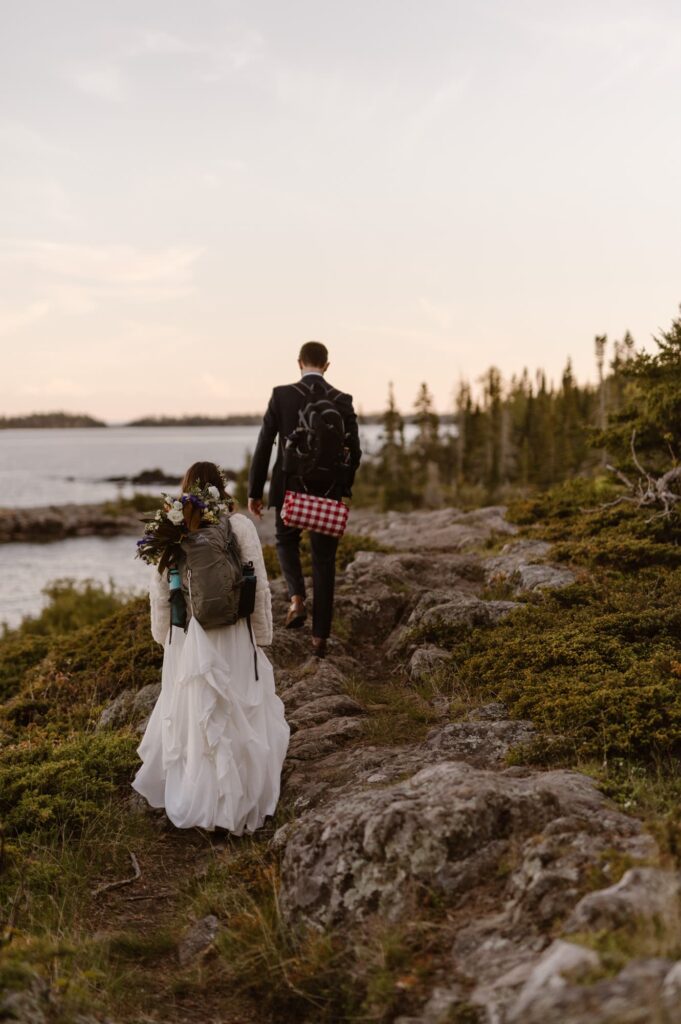 Couple hiking back to the campfire after getting married