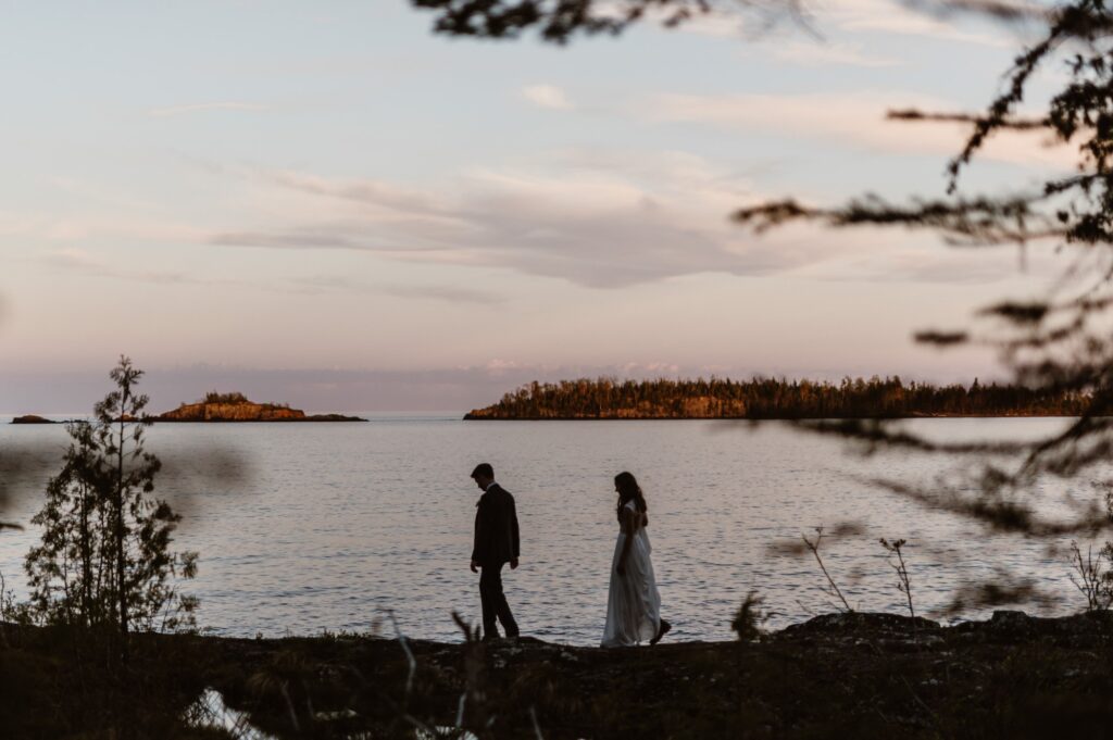 Couple watching the sunset from the shore of Isle Royale National Park