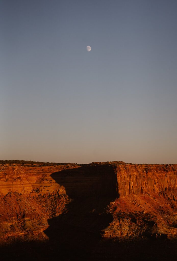 The moon with red cliffs in Moab, Utah