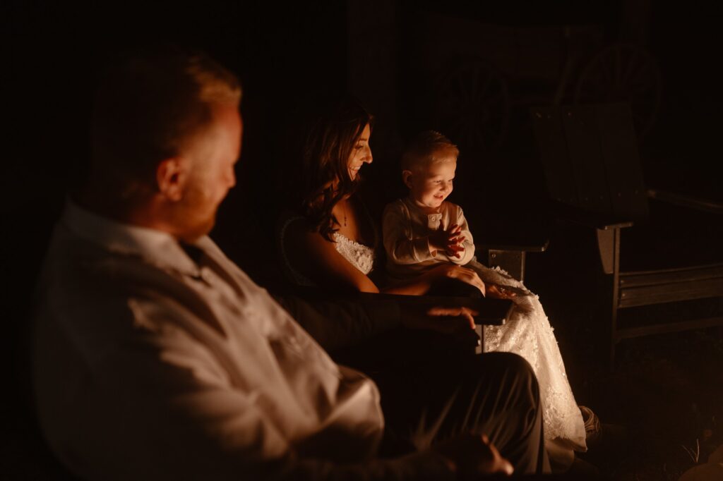 Couple with their son around a campfire after their adventure elopement