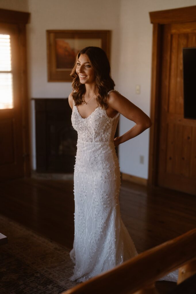 Bride buttoning her elopement dress at Sorrel River Ranch