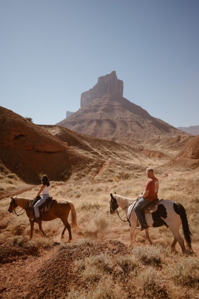 Couple riding horses on their elopement day in the Moab desert