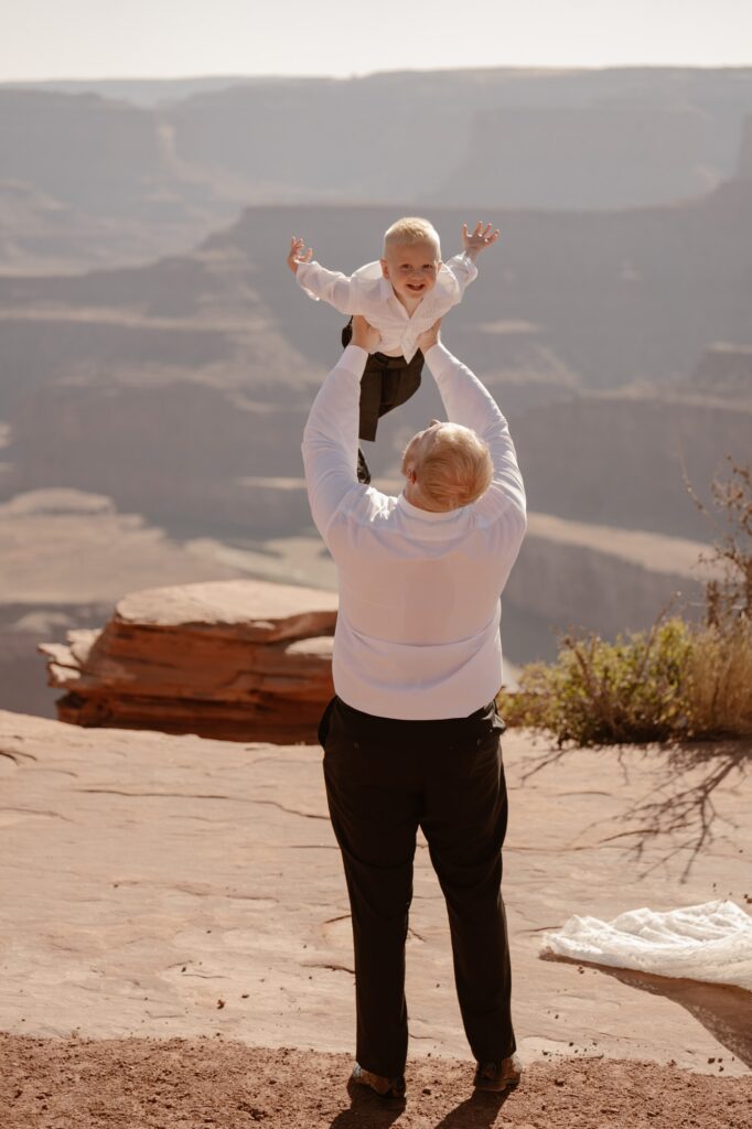 Groom throwing his son in the air after her elopement ceremony