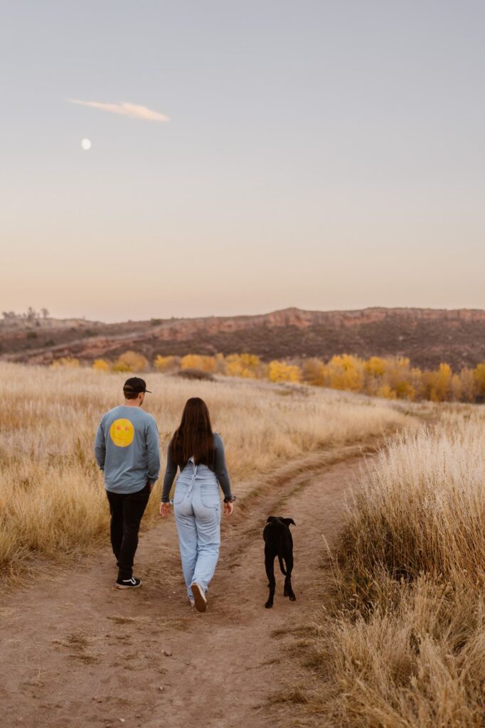 Couple walking off into the sunset with their dog during lifestyle portrait session