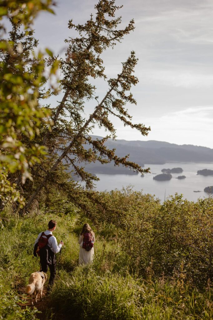 Bride and groom hiking through steep Alaskan terrain on their wedding day