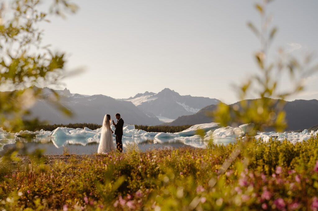 Couple exchanging vows on the edge of a glacial lagoon in Alaska