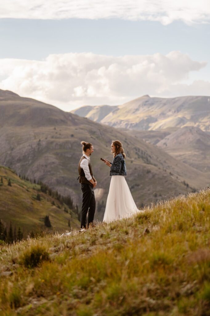 Bride and groom having a destination elopement ceremony on top of a mountain