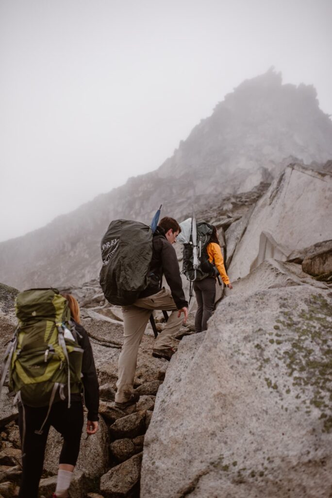 Couple climbing a rocky mountain for a destination elopement in Washington