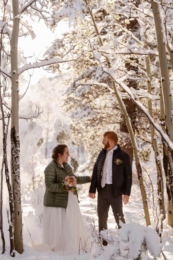 Winter wonderland scene with a bride and groom in the aspen trees