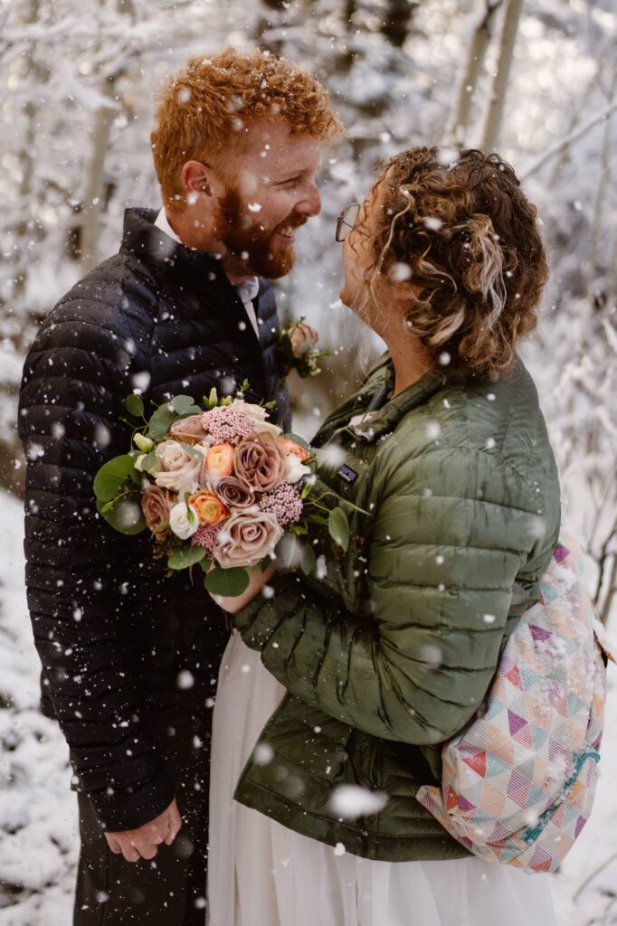 Couple in a wintery scene with snow falling all around