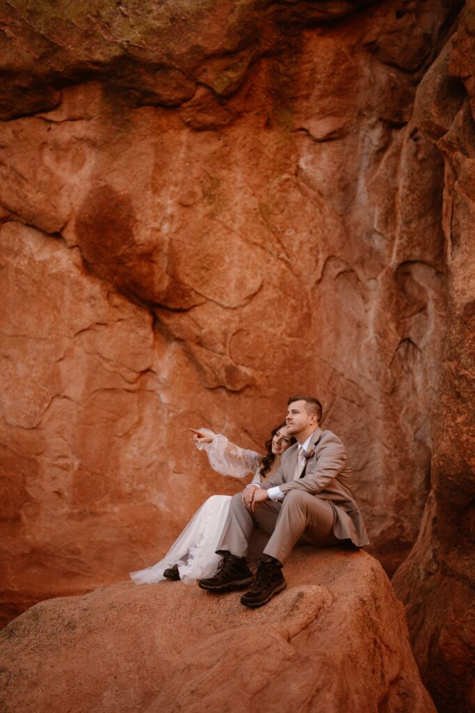 Couple sitting on red rocks at Garden of the Gods on their micro wedding day
