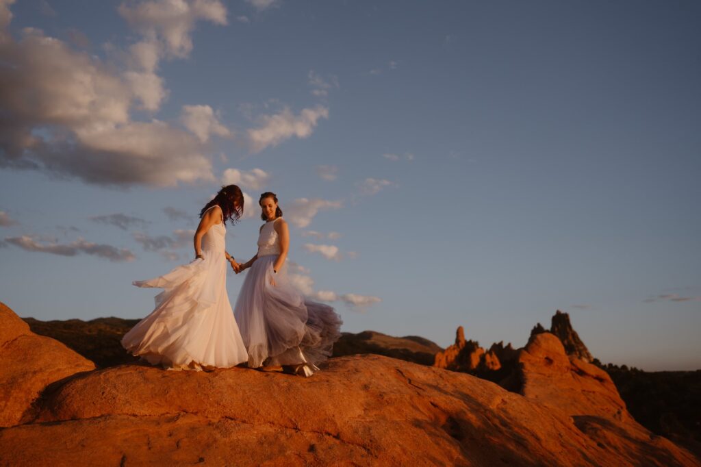 Brides dancing on top of red rocks at Garden of the Gods