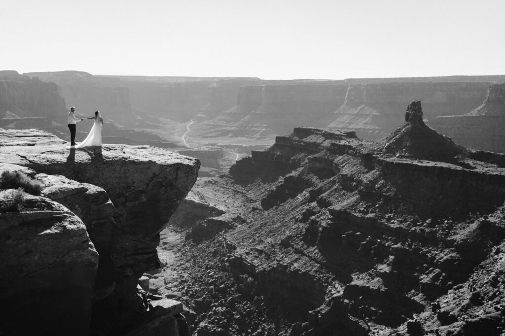 Couple at the edge of a cliff on their elopement day in the desert