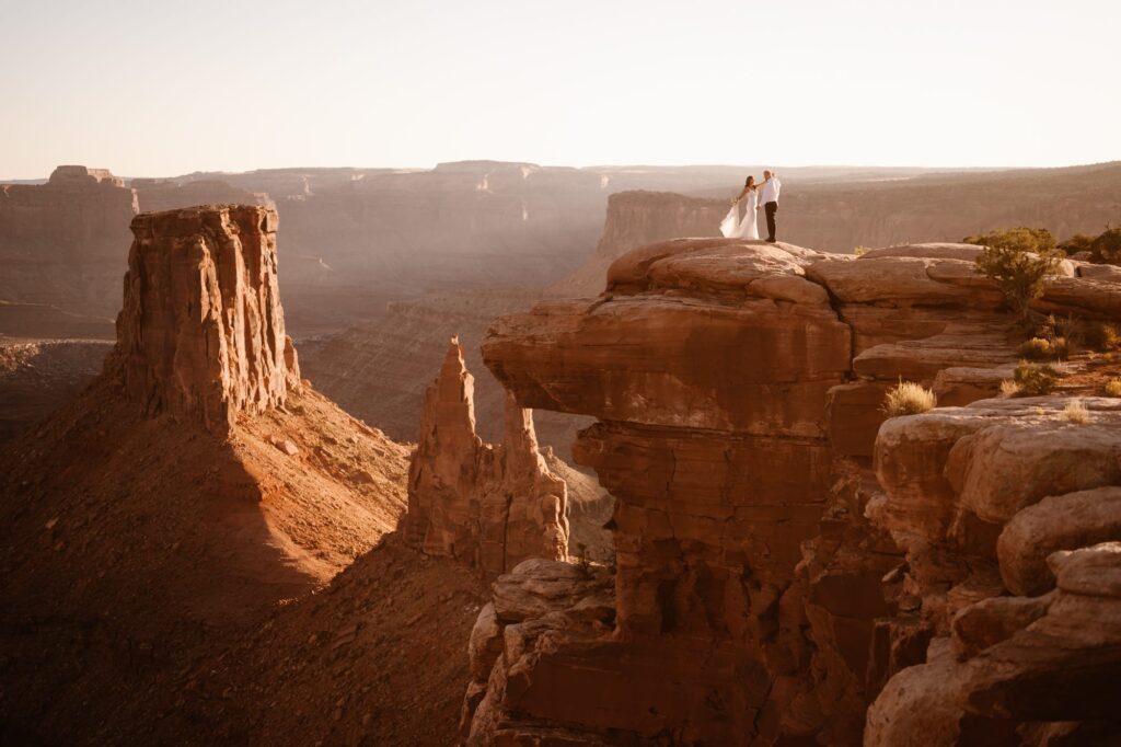 Elopement photo on a cliff in Moab, Utah at sunset