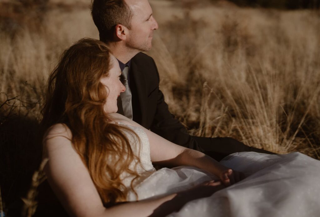 Couple laying in a meadow on their elopement day