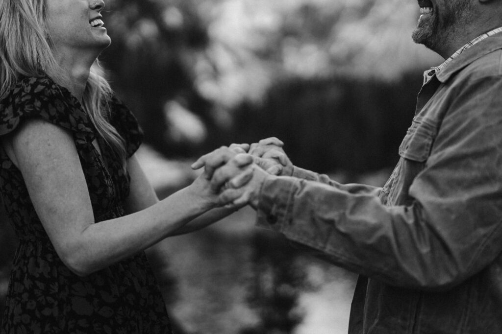 Detail photo of couple laughing and holding hands
