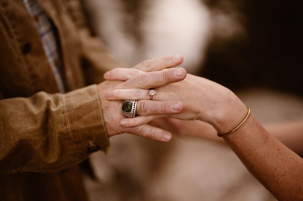 Close up of engagement ring and holding hands