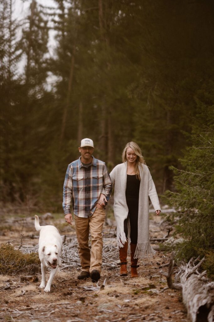 Couple walking through the forest with their dog