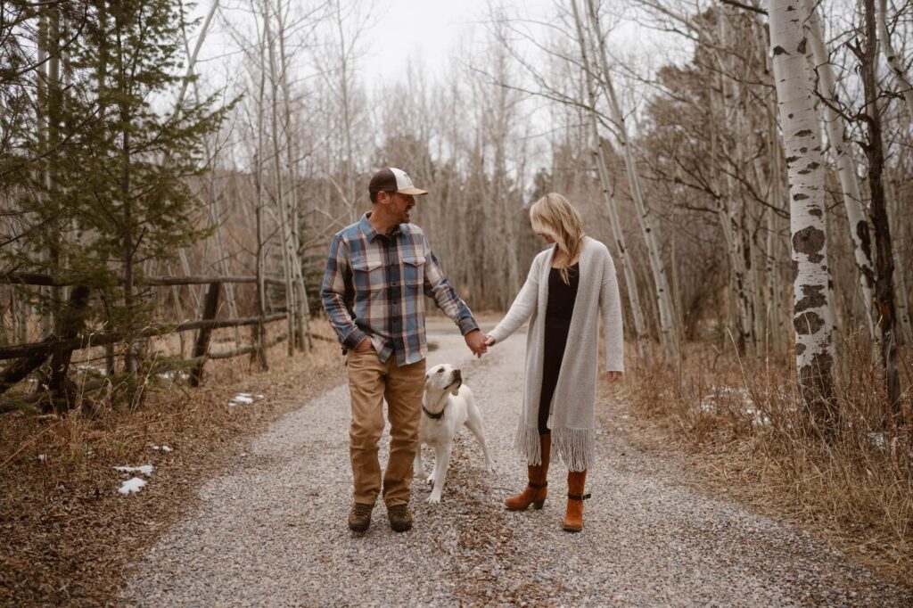 Couple walking down a dirt driveway during an engagement session