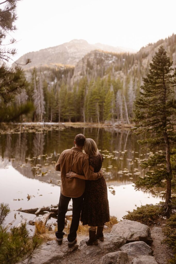 Couple looking off into the mountains and across an alpine lake