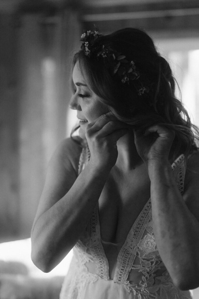 Bride putting earrings on before her wedding day