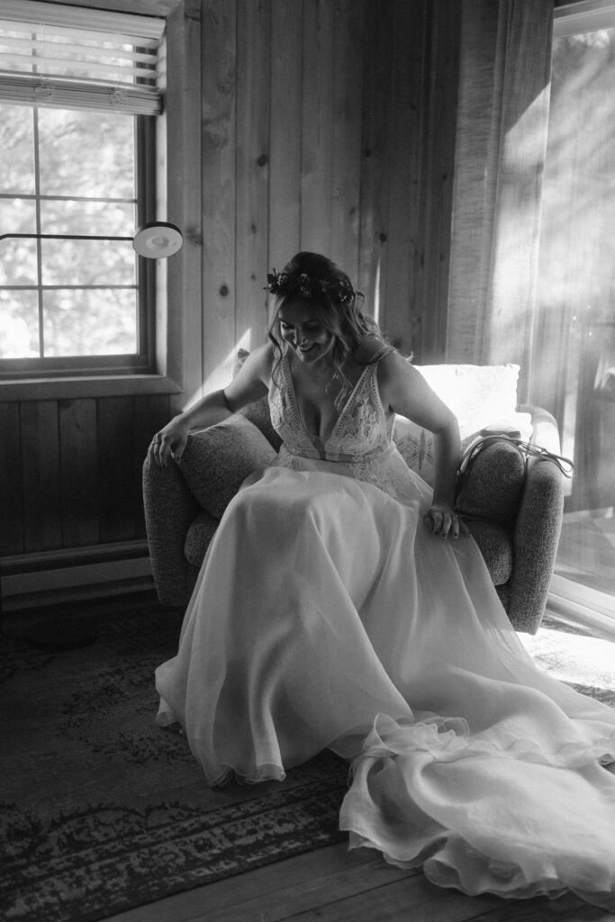 Bride sitting in the window light in a cabin before her elopement