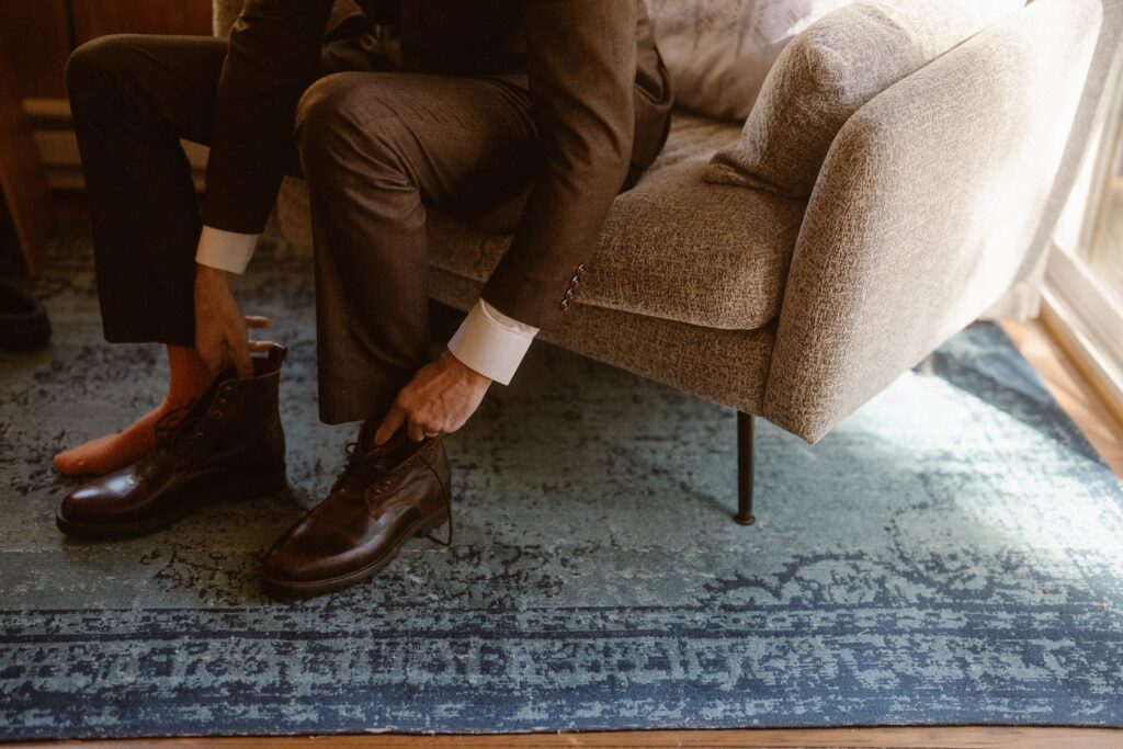 Groom putting on his shoes and final touches before his elopement in Upper Beaver Meadows