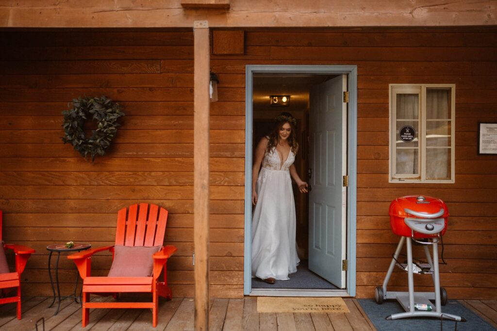 Bride walking out of a cabin to her first look