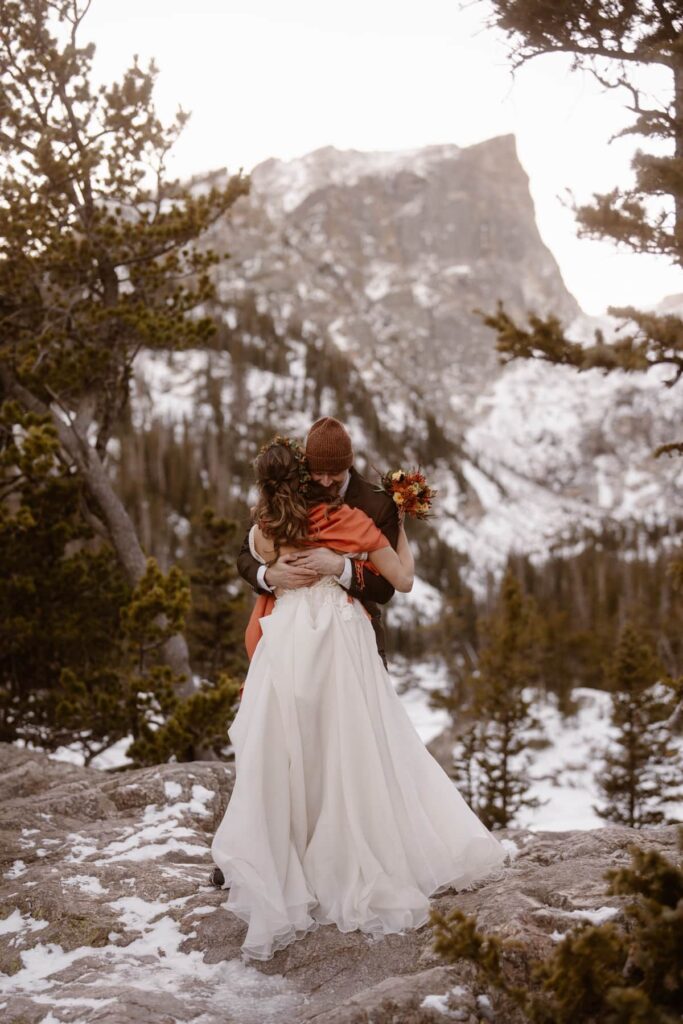 Bride and groom portraits at frozen Dream Lake in Rocky Mountain National Park