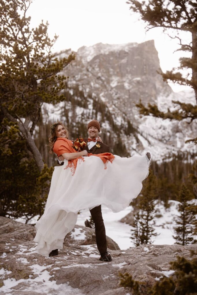 Groom picking up his bride at Dream Lake in Rocky Mountain National Park