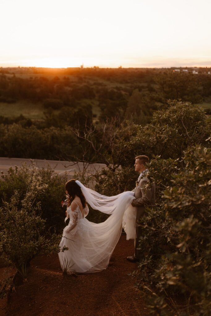 Bride and groom walking as the sun comes up at Garden of the Gods