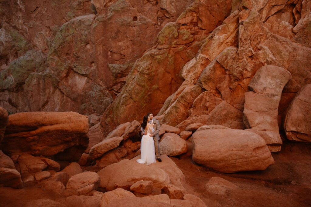 Bride and groom in front of towering red rocks