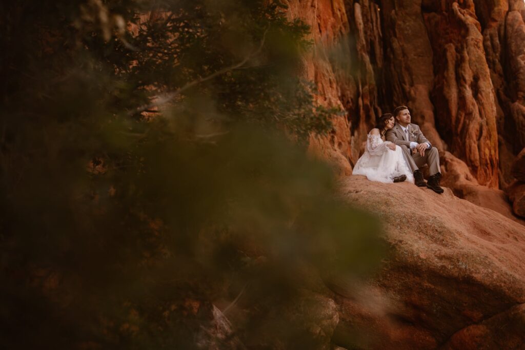 Couple snuggling up and taking in the view at Garden of the Gods on their wedding day