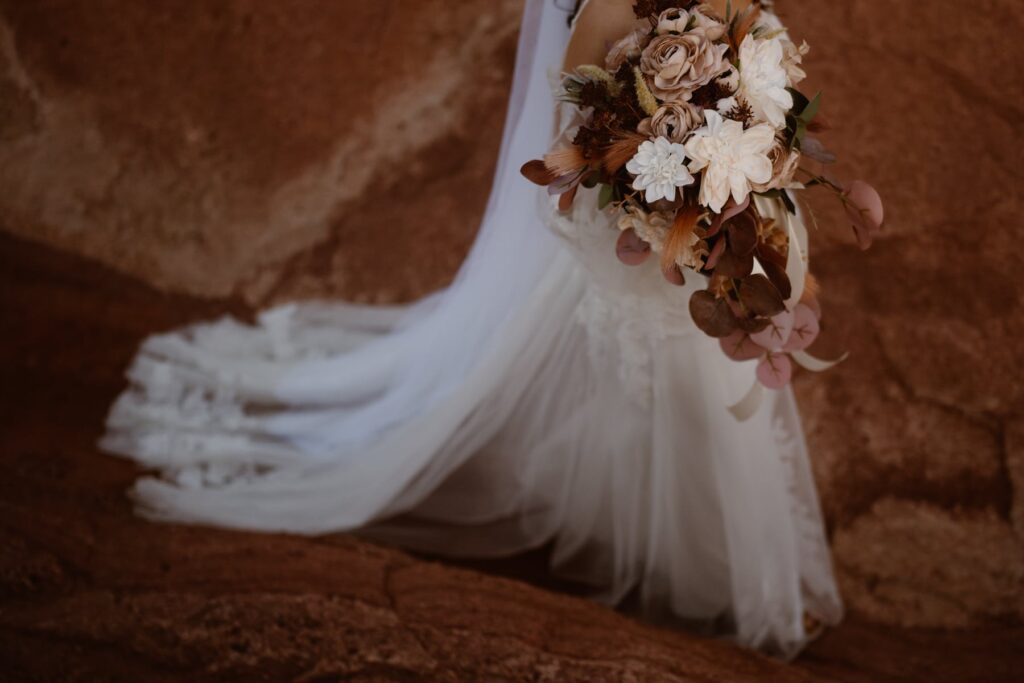 Bride walking out on the red rocks with bouquet at Garden of the Gods