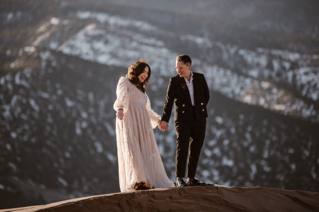 Couple standing on top of the dunes in their wedding attire at Great Sand Dunes National Park