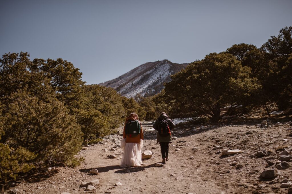 Couple hiking off into the mountains on their elopement day