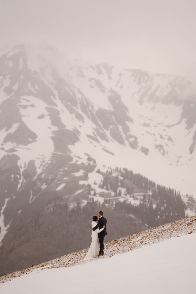 View of snowy mountains in Ouray, Colorado with bride and groom